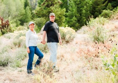 Couple holding hands on a sunny mountain trail at Bogus Basin