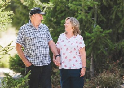 Couple walking hand in hand on a forest path at Bogus Basin